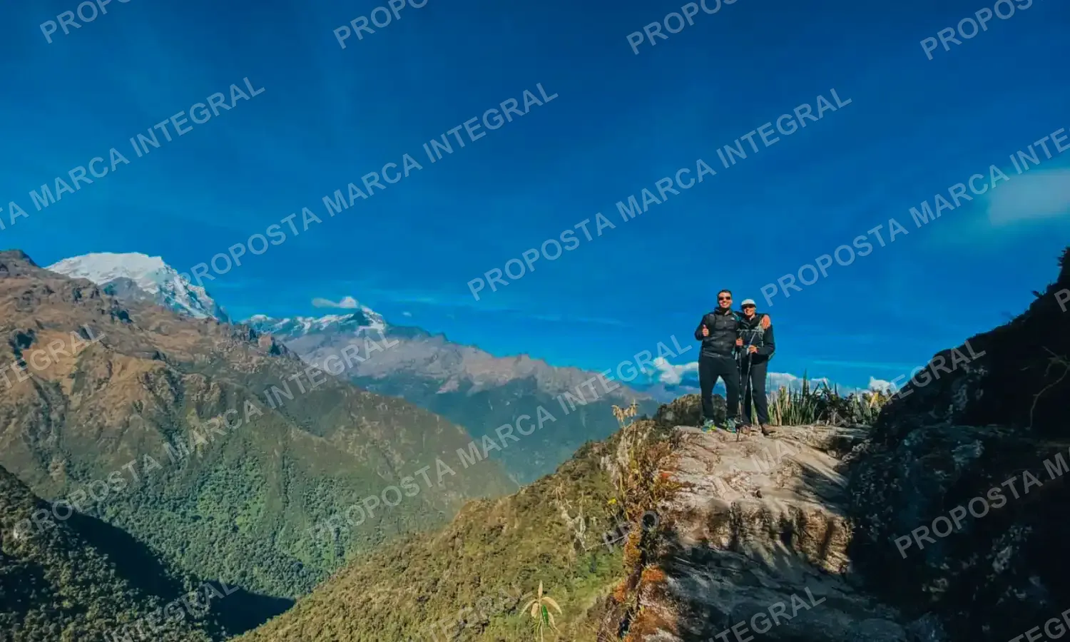 Dois caminhantes num mirante da Trilha Inca, com montanhas nevadas ao fundo